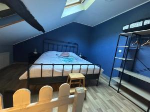 a bedroom with a bed with blue walls and a ladder at Chez Germaine in Bouillon