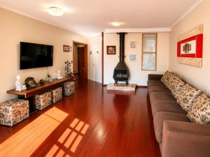 a living room with a couch and a fireplace at Guest house - Casa do Rogério in Caxias do Sul