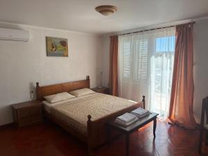 a bedroom with a bed and a large window at Teona-Apartments in Sutomore