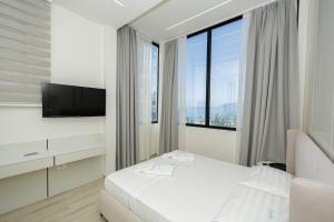 a hotel room with a bed and a tv and window at Laid Hotel in Vlorë