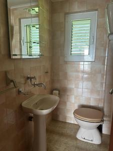 a bathroom with a sink and a toilet and a mirror at Teona-Apartments in Sutomore +24 photos