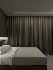 a bed in a bedroom with a curtain at Aelith Rooms in Platamonas