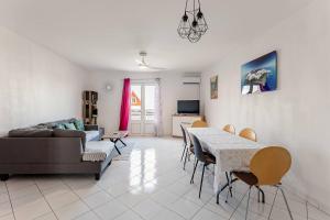 a living room with a couch and a table and chairs at Au Franciscea, climatiseurs, centre ville, sud in Saint-Louis