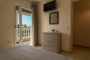 a bedroom with a bed and a mirror and a window at Achillion in Paralia Katerinis