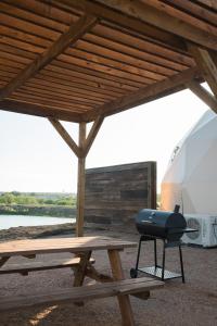a grill sitting on a picnic table under a roof at Stargazer Dome Retreat in San Marcos