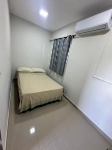 a small bedroom with a bed and a air conditioner at Casa independiente en Ciudad del Este in Ciudad del Este