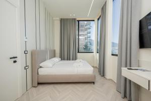 a bedroom with a bed and a large window at Laid Hotel in Vlorë