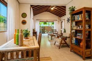 a living room with a table and a book shelf at Pousada Casa Cajá in Arraial d'Ajuda
