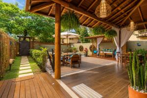 a patio with a wooden deck with tables and chairs at Pousada Casa Cajá in Arraial d'Ajuda