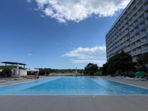 a large swimming pool next to a tall building at Blaxy del Mar Studio Olimp in Olimp