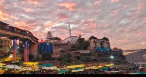 a group of umbrellas and buildings and a bridge at Hotel Shree shivay omkareshwar in Godarpura