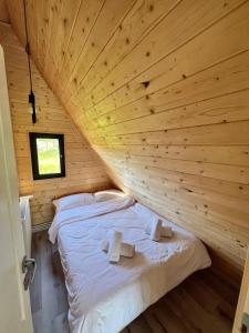 a bed in a room with a wooden ceiling at Crow`s Nest Murmur Măguri in Măguri