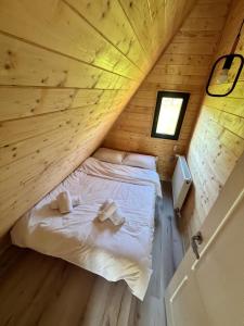 a bed in a small room in a log cabin at Crow`s Nest Murmur Măguri in Măguri +5 photos