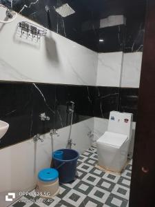 a black and white bathroom with a toilet and a sink at Hotel Shree shivay omkareshwar in Godarpura