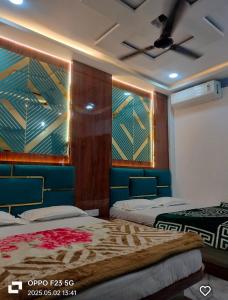 a bedroom with two beds and a ceiling at Hotel Shree shivay omkareshwar in Godarpura