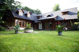 a house with two potted plants in front of it at Siódmy Las in Zawada