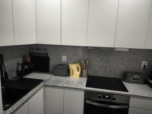 a kitchen with white cabinets and a counter top at Historic Downtown II in Vila Real