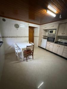 a kitchen with a table and chairs in a room at Casa Gallopin in Foz