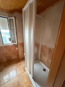 a shower stall in a bathroom with a window at Casa Gallopin in Foz