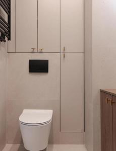 a bathroom with a white toilet and cabinets at GW Apart in Gorzów Wielkopolski