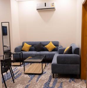a living room with a blue couch and a table at مـهادا Mehada in Taif