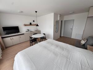 a bedroom with a bed and a table and a kitchen at Apartment Tatry Gerlachov, Vysoke Tatry in Svätý Jur