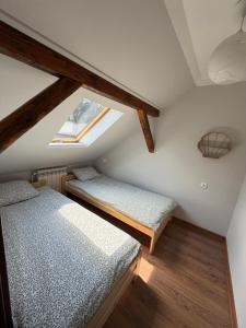 a attic bedroom with two beds and a window at Leśny Domek in Piłka
