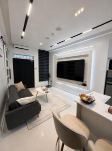 a living room with a couch and a tv at One Plus One Luxe Retreat with Airport Pickups in Sakumona