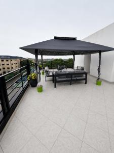 a patio with a black umbrella on top of a building at One Plus One Luxe Retreat with Airport Pickups in Sakumona