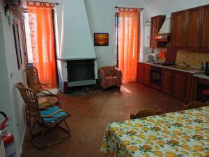 a kitchen with orange curtains and a table and a fireplace at Casa Arancia in Isolabona