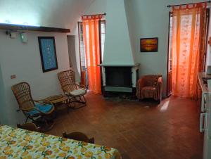 a room with a bed and chairs and a fireplace at Casa Arancia in Isolabona