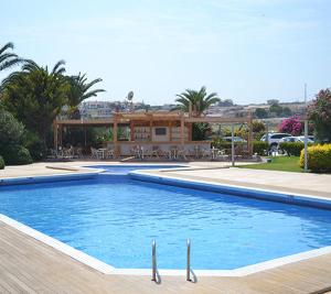 a large swimming pool in front of a house at Cesme Ladin Hotel in Çeşme