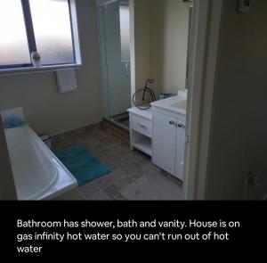 a bathroom with a tub and a sink and a mirror at Digs Homestay in Stratford