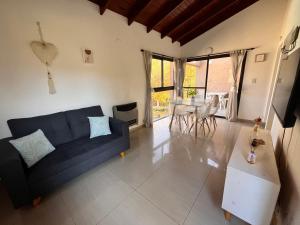 a living room with a blue couch and a table at FlussHaus VGB in Villa General Belgrano