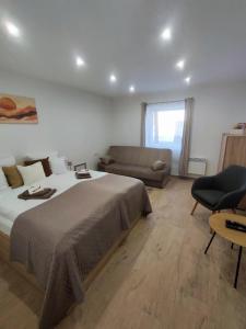 a bedroom with a large bed and a couch at B30 Apartmanok, Eger in Eger