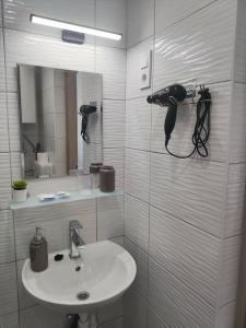 a white bathroom with a sink and a mirror at B30 Apartmanok, Eger in Eger
