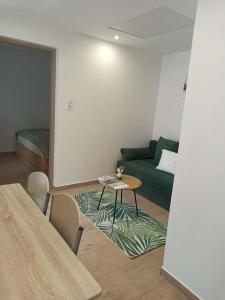 a living room with a green couch and a table at B30 Apartmanok, Eger in Eger