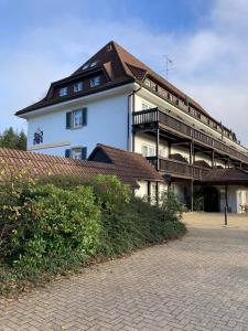 a large white building with a brown roof at Ferienwohnung Alva Hinterzarten in Hinterzarten