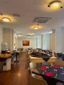 a dining room with tables and chairs and tablesktop at Hotel Aragosta in Cattolica