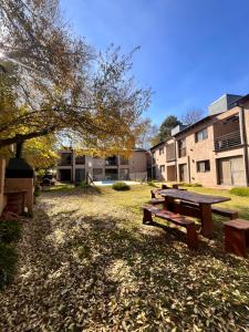 a picnic table in a park in front of a building at FlussHaus VGB in Villa General Belgrano