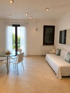 a bedroom with a bed and a table and a dining room at Residence Borgo Punta Villa in La Maddalena