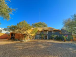 a large blue house with a brick driveway at Echo Mountain Inn in Thabazimbi