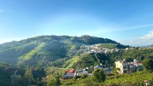 a view of a mountain with houses on it at Arupa Homestay in Ooty