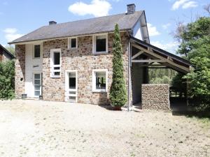 an old brick house with a garage at Le Moulin de Rendeux in Rendeux