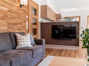 a living room with a couch and a flat screen tv at Chalet Jona in Sonnberg