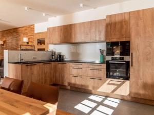 a large kitchen with wooden cabinets and a table at Chalet Jona in Sonnberg