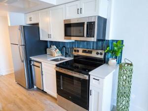 a kitchen with a black stove and a microwave at Lavish Coastal Oceanfront Suite Yachtsman 401 in Myrtle Beach +60 photos