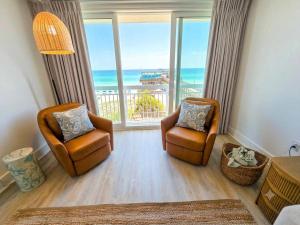 a living room with two chairs and a view of the ocean at Lavish Coastal Oceanfront Suite Yachtsman 401 in Myrtle Beach