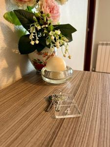 a table with a vase of flowers and a pair of keys at Casa Godinho in São Martinho do Porto