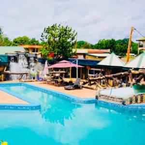 a large swimming pool with a waterfall in the background at point de distraction in Foumban